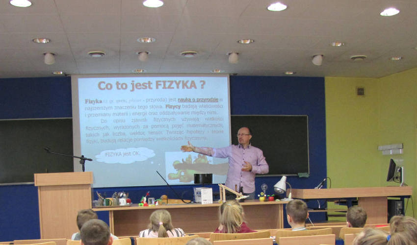 Marek Siłuszyk na tle ekranu ze swoją prezentacją