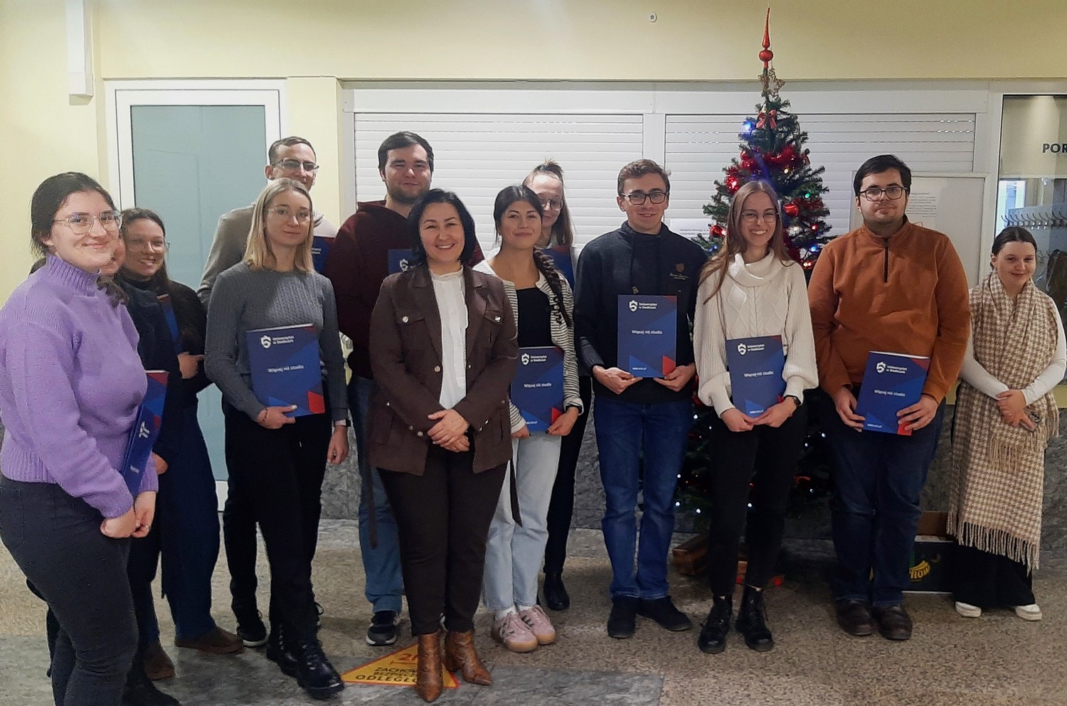 Studenci z dyplomami w dłoniach obok pani Marzena Stańska dziekan WNSP